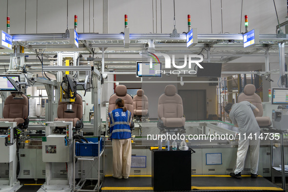 Workers are producing seats ordered by NIO on an assembly line at a workshop of a seating company in Hefei, Anhui province, China, on July 1...