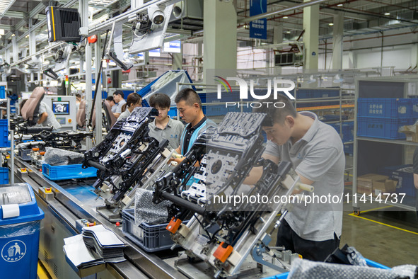 Workers are producing seats ordered by NIO on an assembly line at a workshop of a seating company in Hefei, Anhui province, China, on July 1...