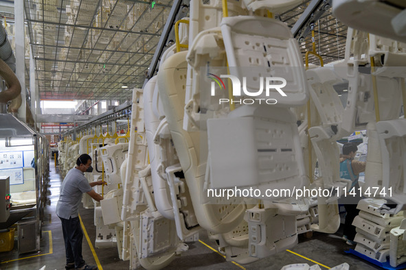 Workers are producing seats ordered by NIO on an assembly line at a workshop of a seating company in Hefei, Anhui province, China, on July 1...