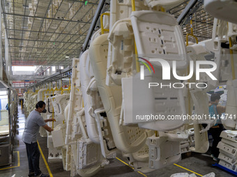 Workers are producing seats ordered by NIO on an assembly line at a workshop of a seating company in Hefei, Anhui province, China, on July 1...