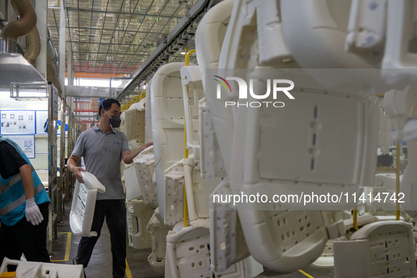 Workers are producing seats ordered by NIO on an assembly line at a workshop of a seating company in Hefei, Anhui province, China, on July 1...