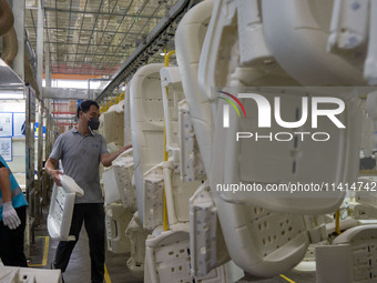 Workers are producing seats ordered by NIO on an assembly line at a workshop of a seating company in Hefei, Anhui province, China, on July 1...