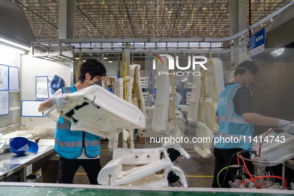 Workers are producing seats ordered by NIO on an assembly line at a workshop of a seating company in Hefei, Anhui province, China, on July 1...