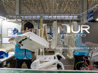 Workers are producing seats ordered by NIO on an assembly line at a workshop of a seating company in Hefei, Anhui province, China, on July 1...