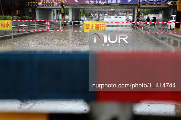 A flood warning sign is being placed on the Nanyuan overpass in the Shizhong district of Zaozhuang city, East China's Shandong province, in...