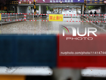 A flood warning sign is being placed on the Nanyuan overpass in the Shizhong district of Zaozhuang city, East China's Shandong province, in...