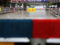 A flood warning sign is being placed on the Nanyuan overpass in the Shizhong district of Zaozhuang city, East China's Shandong province, in...