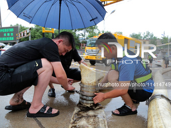 Law enforcement officers of Shizhong District Comprehensive Administrative Law Enforcement Bureau are using a drainage emergency vehicle to...