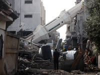 Palestinians are standing on the rubble of Abdullah Azzam Mosque, destroyed in Israeli bombardment in Nuseirat, central Gaza Strip, on July...