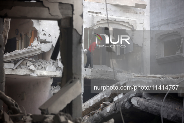 Palestinians are standing on the rubble of Abdullah Azzam Mosque, destroyed in Israeli bombardment in Nuseirat, central Gaza Strip, on July...