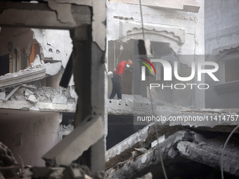 Palestinians are standing on the rubble of Abdullah Azzam Mosque, destroyed in Israeli bombardment in Nuseirat, central Gaza Strip, on July...