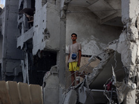 Palestinians are standing on the rubble of Abdullah Azzam Mosque, destroyed in Israeli bombardment in Nuseirat, central Gaza Strip, on July...