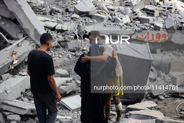 Palestinians are standing on the rubble of Abdullah Azzam Mosque, destroyed in Israeli bombardment in Nuseirat, central Gaza Strip, on July...