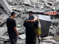 Palestinians are standing on the rubble of Abdullah Azzam Mosque, destroyed in Israeli bombardment in Nuseirat, central Gaza Strip, on July...