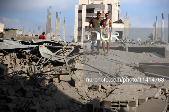 Palestinians are standing on the rubble of Abdullah Azzam Mosque, destroyed in Israeli bombardment in Nuseirat, central Gaza Strip, on July...