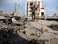 Palestinians are standing on the rubble of Abdullah Azzam Mosque, destroyed in Israeli bombardment in Nuseirat, central Gaza Strip, on July...