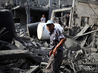 Palestinians are standing on the rubble of Abdullah Azzam Mosque, destroyed in Israeli bombardment in Nuseirat, central Gaza Strip, on July...