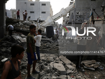 Palestinians are standing on the rubble of Abdullah Azzam Mosque, destroyed in Israeli bombardment in Nuseirat, central Gaza Strip, on July...