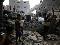 Palestinians are standing on the rubble of Abdullah Azzam Mosque, destroyed in Israeli bombardment in Nuseirat, central Gaza Strip, on July...