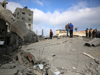 Palestinians are standing on the rubble of Abdullah Azzam Mosque, destroyed in Israeli bombardment in Nuseirat, central Gaza Strip, on July...