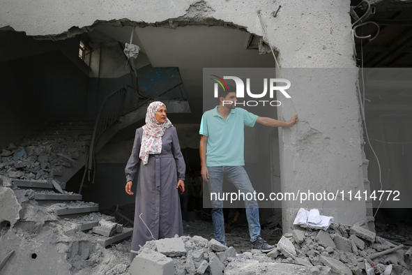 Palestinians are standing on the rubble of Abdullah Azzam Mosque, destroyed in Israeli bombardment in Nuseirat, central Gaza Strip, on July...