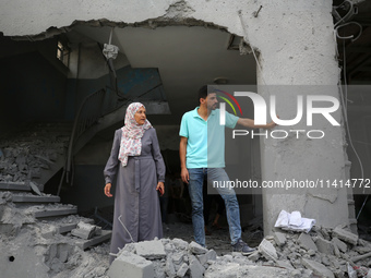 Palestinians are standing on the rubble of Abdullah Azzam Mosque, destroyed in Israeli bombardment in Nuseirat, central Gaza Strip, on July...