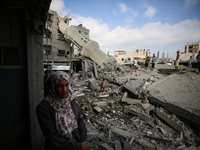 Palestinians are standing on the rubble of Abdullah Azzam Mosque, destroyed in Israeli bombardment in Nuseirat, central Gaza Strip, on July...