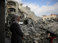 Palestinians are standing on the rubble of Abdullah Azzam Mosque, destroyed in Israeli bombardment in Nuseirat, central Gaza Strip, on July...