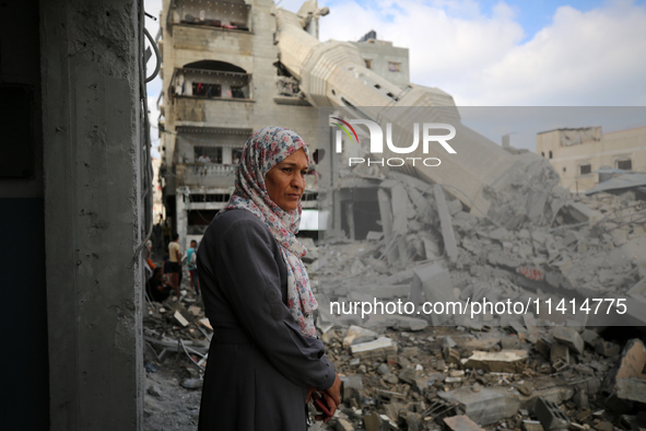 Palestinians are standing on the rubble of Abdullah Azzam Mosque, destroyed in Israeli bombardment in Nuseirat, central Gaza Strip, on July...