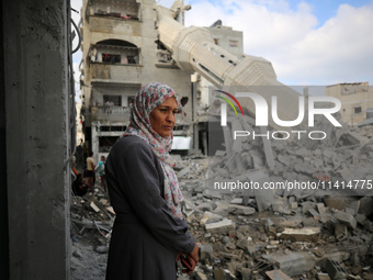 Palestinians are standing on the rubble of Abdullah Azzam Mosque, destroyed in Israeli bombardment in Nuseirat, central Gaza Strip, on July...