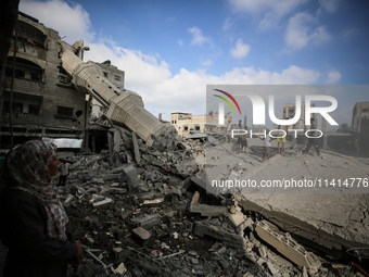 Palestinians are standing on the rubble of Abdullah Azzam Mosque, destroyed in Israeli bombardment in Nuseirat, central Gaza Strip, on July...