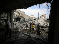 Palestinians are standing on the rubble of Abdullah Azzam Mosque, destroyed in Israeli bombardment in Nuseirat, central Gaza Strip, on July...