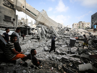 Palestinians are standing on the rubble of Abdullah Azzam Mosque, destroyed in Israeli bombardment in Nuseirat, central Gaza Strip, on July...