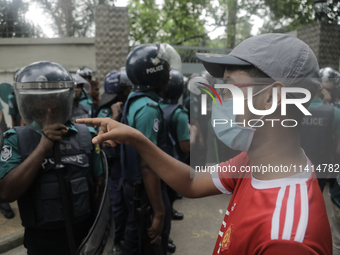 Anti-quota protestors are pointing at a police officer to answer the reason for shooting their fellow protester who died yesterday in Dhaka,...