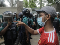 Anti-quota protestors are pointing at a police officer to answer the reason for shooting their fellow protester who died yesterday in Dhaka,...