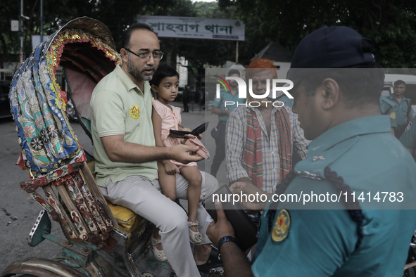 Police officers are checking IDs of civilians as the entrance of Dhaka University area is restricted due to violence in Dhaka, Bangladesh, o...