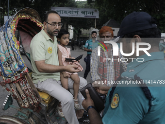 Police officers are checking IDs of civilians as the entrance of Dhaka University area is restricted due to violence in Dhaka, Bangladesh, o...