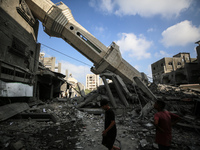 Palestinians are standing on the rubble of Abdullah Azzam Mosque, destroyed in Israeli bombardment in Nuseirat, central Gaza Strip, on July...