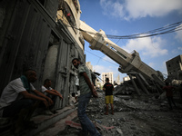 Palestinians are standing on the rubble of Abdullah Azzam Mosque, destroyed in Israeli bombardment in Nuseirat, central Gaza Strip, on July...