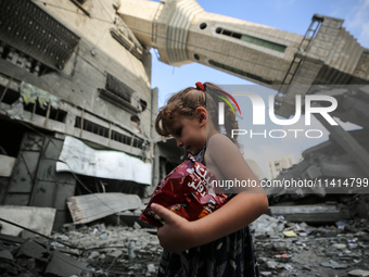 A Palestinian girl is walking in front of Abdullah Azzam Mosque, destroyed in Israeli bombardment, in Nuseirat, central Gaza Strip, on July...