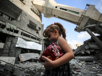 A Palestinian girl is walking in front of Abdullah Azzam Mosque, destroyed in Israeli bombardment, in Nuseirat, central Gaza Strip, on July...