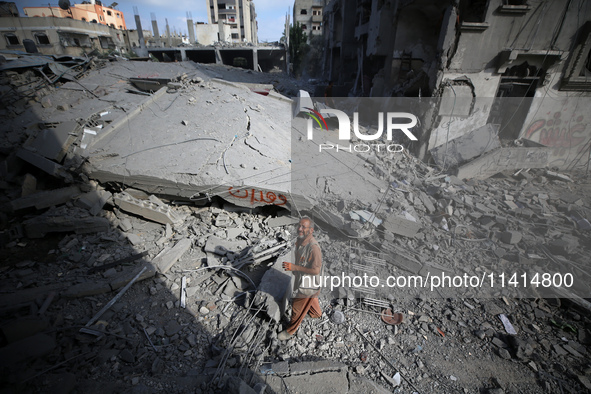 Palestinians are standing on the rubble of Abdullah Azzam Mosque, destroyed in Israeli bombardment in Nuseirat, central Gaza Strip, on July...