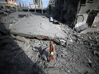 Palestinians are standing on the rubble of Abdullah Azzam Mosque, destroyed in Israeli bombardment in Nuseirat, central Gaza Strip, on July...