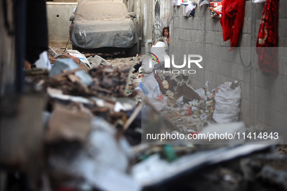 Palestinians are inspecting a house destroyed in an Israeli strike, amid the Israel-Hamas conflict, in Nusairat refugee camp, in the central...