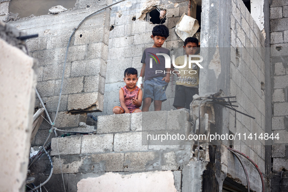 Palestinians are inspecting a house destroyed in an Israeli strike, amid the Israel-Hamas conflict, in Nusairat refugee camp, in the central...