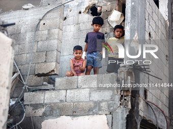 Palestinians are inspecting a house destroyed in an Israeli strike, amid the Israel-Hamas conflict, in Nusairat refugee camp, in the central...