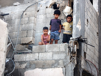 Palestinians are inspecting a house destroyed in an Israeli strike, amid the Israel-Hamas conflict, in Nusairat refugee camp, in the central...