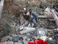 Palestinians are inspecting a house destroyed in an Israeli strike, amid the Israel-Hamas conflict, in Nusairat refugee camp, in the central...