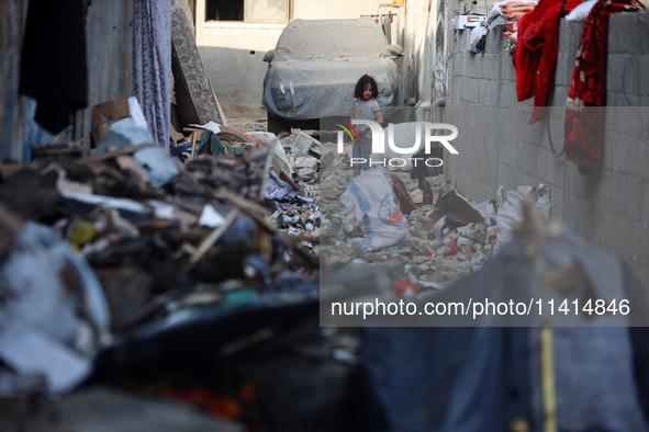 Palestinians are inspecting a house destroyed in an Israeli strike, amid the Israel-Hamas conflict, in Nusairat refugee camp, in the central...