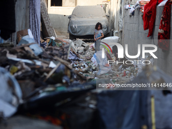 Palestinians are inspecting a house destroyed in an Israeli strike, amid the Israel-Hamas conflict, in Nusairat refugee camp, in the central...